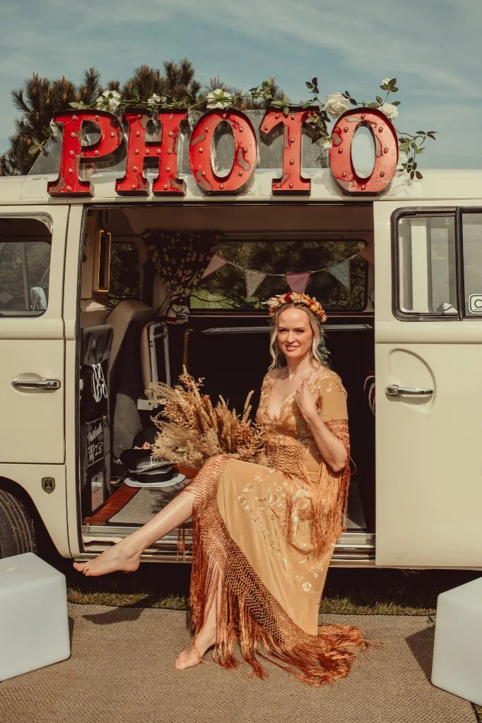 Bride seated in a vintage camper van photo booth at Woodhill Weddings, Faversham, Kent