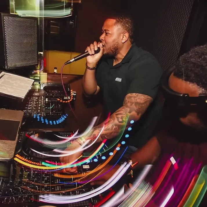 The Boom Box UK DJ and MC performing at an event with decks and colourful light trails